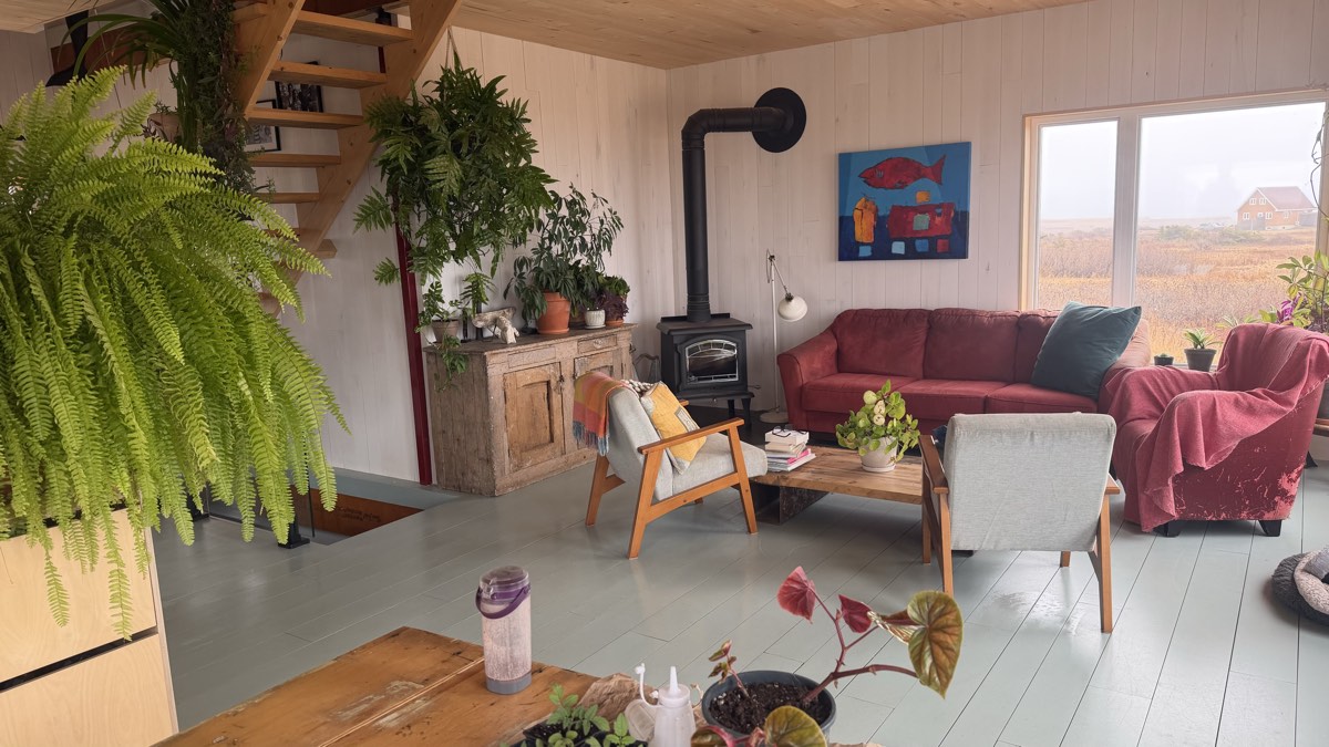 Salon avec poêle et fauteuils, plancher propre et lumineux
