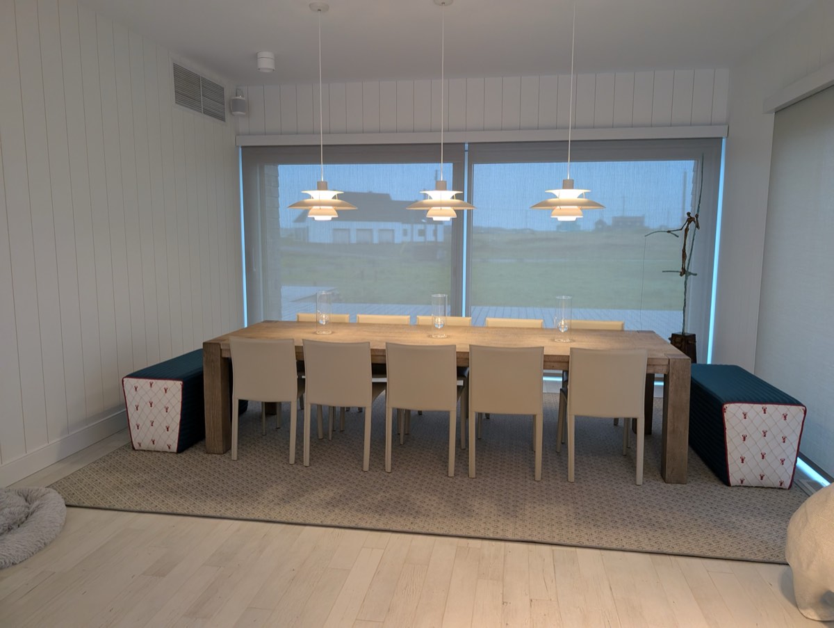 Salle à manger lumineuse, table et chaises alignées